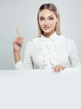 Smiling business woman holding white empty board background with copy space for advertising marketing or product placement. Successful businesswoman portraitの写真素材