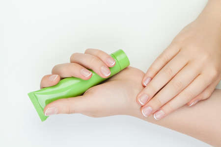 Manicure concept with hands and creame tube on white background.の写真素材