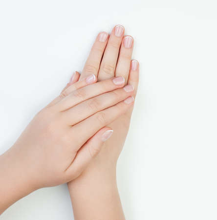 Beautiful female hands on white manicure tableの写真素材