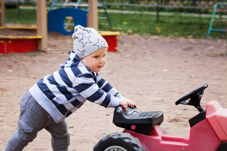 Happy child playing toy car outdoors in playgroundの写真素材