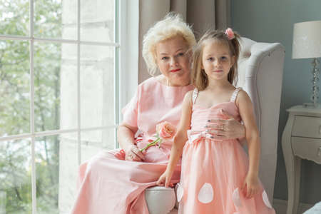 Happy grandmother and granddaughter at home. Older woman and child girlの写真素材