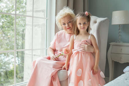 Happy grandmother and granddaughter. Older woman and child girl at homeの写真素材