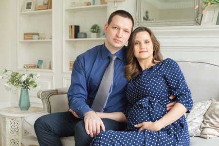 Portrait of happy pregnant couple at homeの写真素材