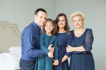 Grandmother and mother, daughter, father. Happy family at home.の写真素材