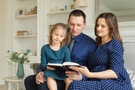 Happy family with book at homeの写真素材