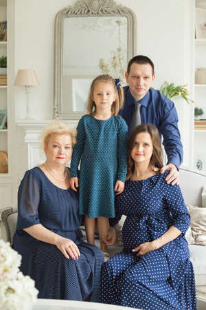 Happy family. Smiling mother, daughter, father and grandmother at home. Three generationの写真素材