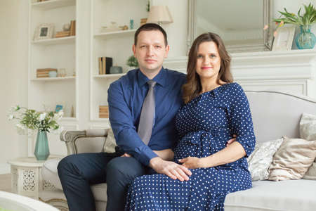 Smiling pregnant couple at homeの写真素材