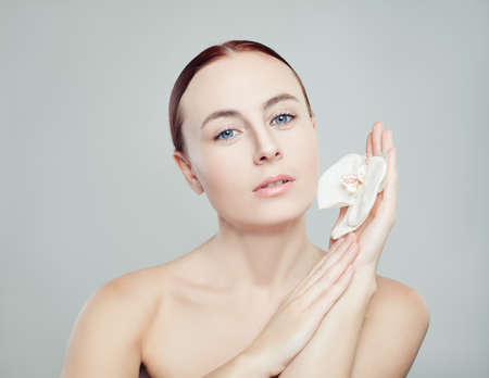 Spa and skincare concept. Beautiful woman with healthy skin and flower on white backgroundの写真素材