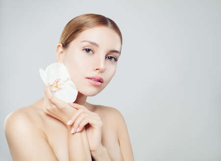 Attractive spa woman portrait. Smiling girl with healthy skin and flowerの写真素材