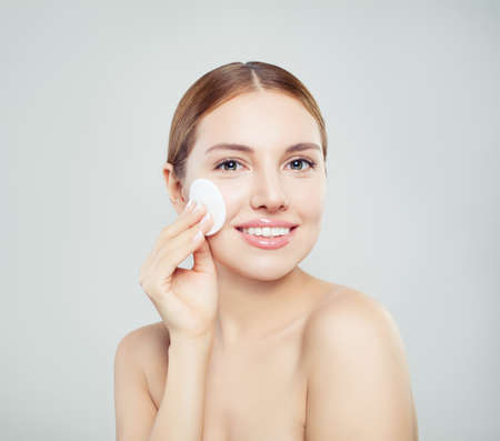 Woman cotton pad face portrait. Beautiful young smiling woman with clean cotton padsの写真素材