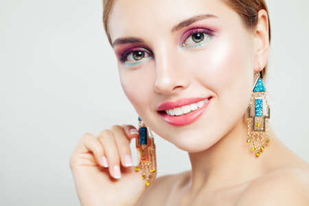Closeup beauty portrait of glamorous woman with makeup and gold earrings, portrait