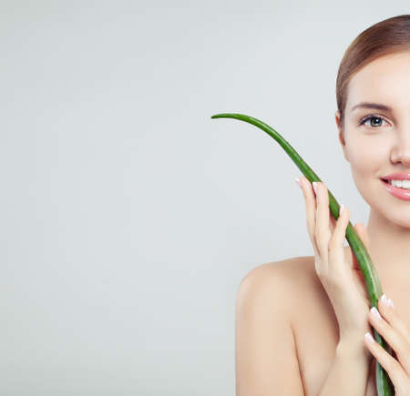Beautiful smiling woman with healthy skin and aloe vera leaf, skincare conceptの写真素材