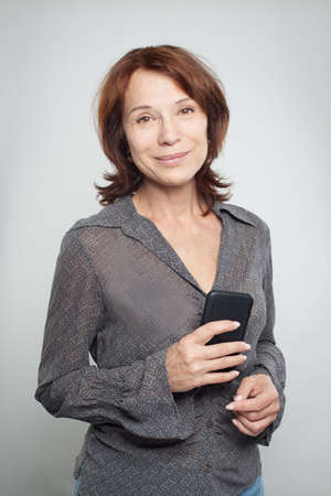 Happy mature business woman with cell phoneの写真素材