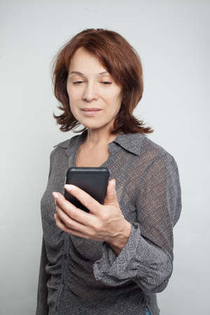Mature woman with mobile cell phone, portraitの写真素材