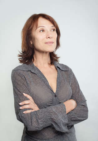 Confident business woman with crossed arms looking up on whiteの写真素材