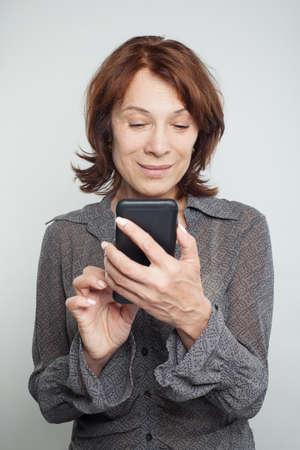 Mature woman texting on whiteの写真素材