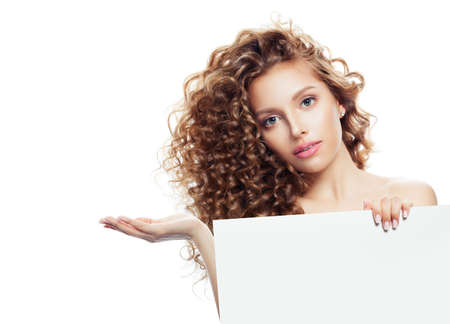 Young blonde woman with open hand holding white empty boardの写真素材