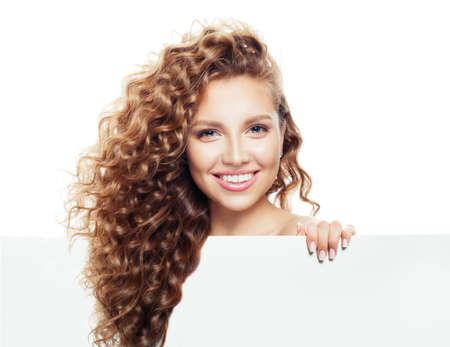 Cheerful girl holding white empty paper board background with copy space for advertising marketing or product placement isolated on whiteの写真素材