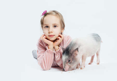 Cute little girl with pig. Child and petの写真素材