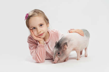 Cute child girl with pig, portrait. Child and petの写真素材