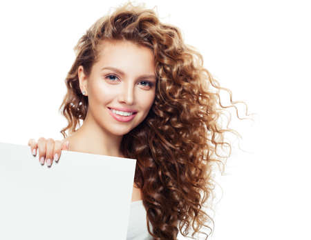 Young blonde woman with white empty paper board for advertising marketing or product placement isolated on whiteの写真素材