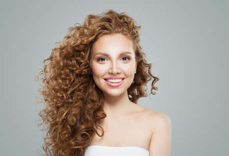 Happy redhead woman with long healthy curly hair. Cute female faceの写真素材
