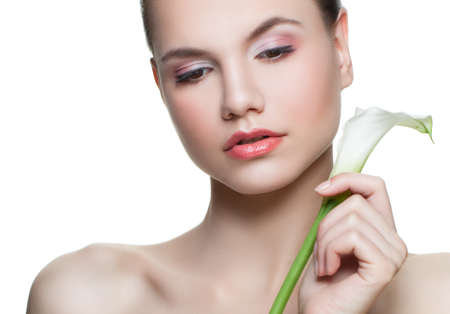 Spa face. Young woman with white flower isolated on whiteの写真素材