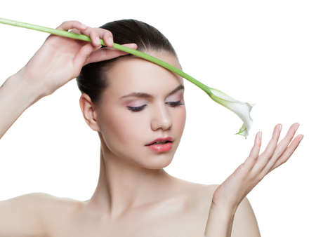 Young beauty woman holding calla lily flower isolated on white background. Beautiful model face with clear skin isolatedの写真素材