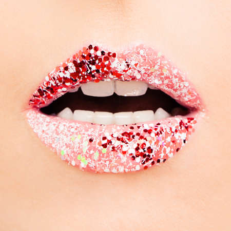 Closeup macro creative makeup. Beautiful female lips with red and pink lipstick with glitterの写真素材
