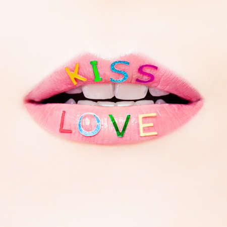 Valentine's day and love concept with beautiful female lips closeup. Perfect female smile with glitter lipstick makeup and love signの写真素材