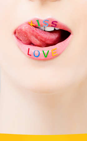 Woman licking her lip with love symbol. Valentine's day and love concept with beautiful female lips closeup, cell wallpaper backgroundの写真素材
