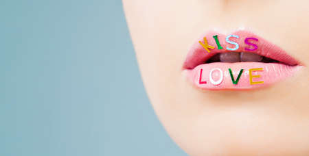 Beautiful lips closeup on blue background. Perfect female lip with bright makeup and pink lipstick.Valentine's day, love and passion conceptの写真素材