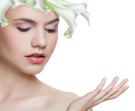Spa beauty. Young woman with white flower isolated on white background. Beautiful face. Facial treatment, cosmetology, skin care and spring beauty conceptの写真素材