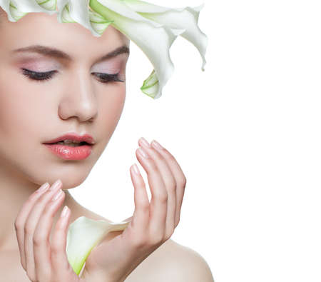 Healthy woman and white flowers isolated. Beautiful female model face closeup on white background. Facial treatment, cosmetology, beauty, skincare and spa conceptの写真素材