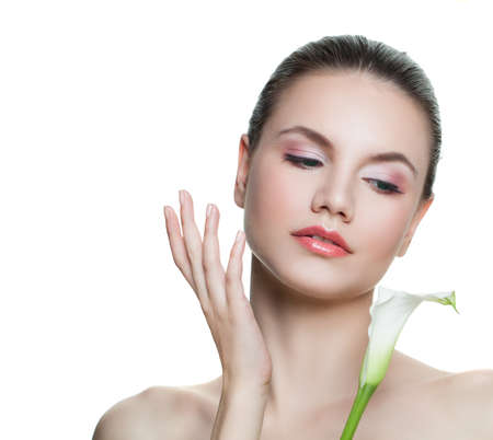 Attractive young woman applying cream on her face. Perfect girl with flower isolated on white backgroundの写真素材