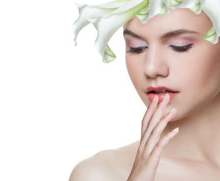 Young woman with white flower thinking isolated on white background. Face closeup. Facial treatment, cosmetology, beauty, skincare and spa conceptの写真素材