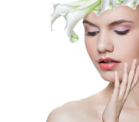 Floral blossom portrait of cute young woman face with white flower isolatedの写真素材