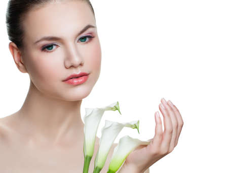 Spa portrait of beautiful female face isolated on white background. Nice girl with white flowersの写真素材