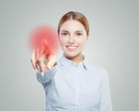 Pointing hand of happy woman on gray