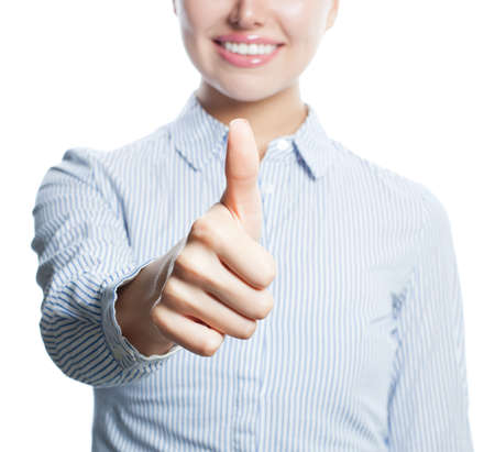 Thumb up closeup. Hand of smiling woman showing thumb up isolated on whiteの写真素材