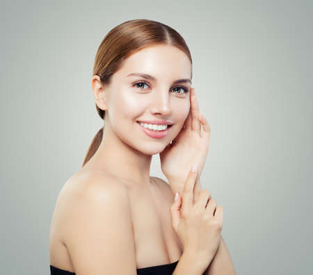 Happy girl portrait. Young woman face with clear skin and natural makeup smilingの写真素材