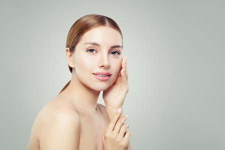 Nice girl with clear skin. Young woman face on whiteの写真素材
