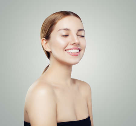 Pretty smiling woman portrait. Beautiful girl face with clear skin portraitの写真素材