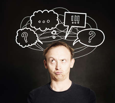 Casual man thinking with question mark and hand drawing sketch bubble on blackboard background. Choice, problem and solution conceptの写真素材