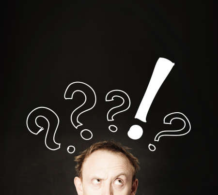 Funny man face with hand drawing question marks on blackboard background