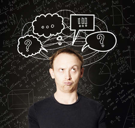 Casual man with hand drawing question mark and sketch bubble on blackboard science background. Education, student exam and brainstorm conceptの写真素材