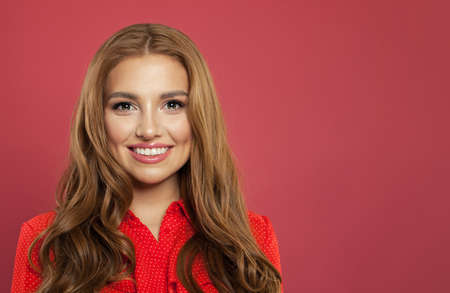 Close up portrait of young beautiful woman smiling. Cute cheerful girl face on pink background with copy spaceの写真素材