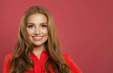 Successful woman smiling on pink background. Portrait of young beautiful cute cheerful model girl with cute smile. Face close upの写真素材