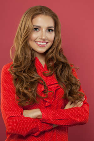 Happy cheerful girl smiling and looking at camera, portrait. Pretty woman on pink backgroundの写真素材