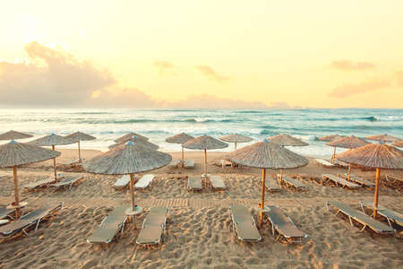 Morning beach, umbrellas, sunbeds and dawn sky. Summer holiday conceptの写真素材